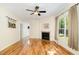 Bright living room featuring hardwood floors, a fireplace, a ceiling fan, and a view to the entryway at 2913 Escondido Farm Rd, Garner, NC 27529