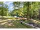 Lush backyard featuring mature trees, seating area and a scenic pond with fountain at 2913 Escondido Farm Rd, Garner, NC 27529