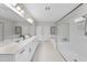 Luxurious primary bathroom featuring double vanities, sleek fixtures, a glass-enclosed shower, and a soaking tub at 300 Scotland Dr, Youngsville, NC 27596