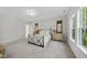 Spacious bedroom with carpet flooring, two dressers with lamps, and two expansive, bright windows at 300 Scotland Dr, Youngsville, NC 27596
