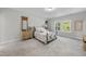 Sunlit bedroom featuring plush carpet, two large windows, and matching nightstands with wooden accents at 300 Scotland Dr, Youngsville, NC 27596