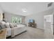 Bright bedroom boasts three large windows, neutral carpet, and an adjacent entertainment center with storage at 300 Scotland Dr, Youngsville, NC 27596