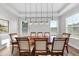 Bright dining room featuring a tray ceiling, modern lighting, and a large wooden table with seating at 300 Scotland Dr, Youngsville, NC 27596