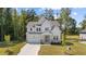 Charming two-story home featuring light exterior paint, stone accents, and a well-manicured front yard with mature trees at 300 Scotland Dr, Youngsville, NC 27596