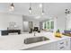 Close-up of a kitchen island, highlighting sink, cabinetry, and living area in the background at 300 Scotland Dr, Youngsville, NC 27596