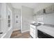 Well-lit laundry room featuring a modern washer and dryer, practical shelving, and stylish wood-look flooring at 300 Scotland Dr, Youngsville, NC 27596