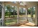 Covered and screened-in porch with wood flooring overlooking trees at 300 Scotland Dr, Youngsville, NC 27596