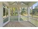 A screened porch with wooden floors and white railings offers views of the wooded backyard at 300 Scotland Dr, Youngsville, NC 27596