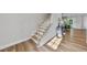 Elegant staircase with wooden steps and white risers, complemented by wood floors and modern décor at 300 Scotland Dr, Youngsville, NC 27596