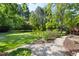 Landscaped backyard featuring a lush lawn, mature trees and a stone walkway at 30150 Walser, Chapel Hill, NC 27517