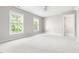 Spacious bedroom featuring two windows, neutral carpeting, and an en-suite bathroom at 30150 Walser, Chapel Hill, NC 27517