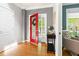 Bright foyer with hardwood floors, a red door, and a black accent table, leading to a comfortable seating area at 30150 Walser, Chapel Hill, NC 27517