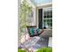 Close-up of a comfortable porch swing with plush pillows, set against a backdrop of climbing plants and a paneled window at 30150 Walser, Chapel Hill, NC 27517
