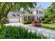 Charming two-story home featuring a well-manicured lawn, a driveway, and a covered porch adorned with American flags at 30150 Walser, Chapel Hill, NC 27517