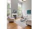 Sunlit living room featuring hardwood floors, a fireplace, and large windows offering a scenic outdoor view at 30150 Walser, Chapel Hill, NC 27517