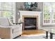 Cozy reading nook with a fireplace, comfortable armchair, and natural light streaming through the windows at 30150 Walser, Chapel Hill, NC 27517