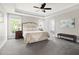 Spacious main bedroom featuring tray ceilings, a ceiling fan, and ample natural light from large windows at 30150 Walser, Chapel Hill, NC 27517
