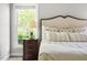 Comfortable main bedroom featuring a plush bed, a nightstand, and a window with a view of the outdoors at 30150 Walser, Chapel Hill, NC 27517