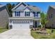 Charming two-story home featuring a two-car garage, gray siding, and a well-manicured front lawn at 3017 Ginger Hill Ln, Durham, NC 27703