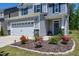 Charming home featuring a well-manicured front yard with colorful flowers and a two-car garage at 3017 Ginger Hill Ln, Durham, NC 27703