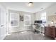 Well-lit home office with adjustable desk, comfortable seating, and natural light from three windows at 3017 Ginger Hill Ln, Durham, NC 27703