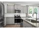 Modern kitchen featuring gray cabinets, granite countertops, stainless steel appliances, and a stylish subway tile backsplash at 3017 Ginger Hill Ln, Durham, NC 27703