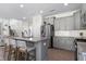 Modern kitchen featuring gray cabinets, granite countertops, stainless steel appliances, and an island with bar seating at 3017 Ginger Hill Ln, Durham, NC 27703