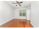 Bedroom features hardwood floors, a ceiling fan, a large window, and neutral-colored walls at 302 Red Elm Dr, Durham, NC 27713