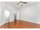 Bedroom features hardwood floors, a ceiling fan, and an adjoining bathroom and closet at 302 Red Elm Dr, Durham, NC 27713