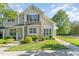 Charming townhome with stone accents, manicured lawn, and lush landscaping provides delightful curb appeal at 302 Red Elm Dr, Durham, NC 27713