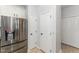 Modern kitchen featuring stainless steel refrigerator, white cabinets, and neutral tile flooring at 302 Red Elm Dr, Durham, NC 27713
