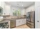 Well-equipped kitchen with stainless steel appliances, white cabinetry, and natural light from the window at 302 Red Elm Dr, Durham, NC 27713