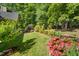 Lush backyard with manicured lawn, colorful flowers, and mature trees at 3035 Tavistock Dr, Durham, NC 27712