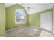 Bright bedroom features an arched window, ceiling fan, and neutral carpet at 3035 Tavistock Dr, Durham, NC 27712