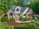 Charming two-story home with brick and siding, a well-manicured lawn, and mature trees at 3035 Tavistock Dr, Durham, NC 27712