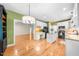Open kitchen features white cabinets, granite countertops, stainless appliances, and hardwood flooring at 3035 Tavistock Dr, Durham, NC 27712