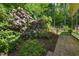 Beautiful landscaping with flowering plants and brick pathway along the house at 3035 Tavistock Dr, Durham, NC 27712