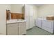 Well-equipped laundry room boasts modern washer and dryer, ample storage cabinets, and a utility sink at 3035 Tavistock Dr, Durham, NC 27712