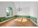 Bright living room with hardwood floors, large windows, a decorative chandelier, and wainscotting at 3035 Tavistock Dr, Durham, NC 27712