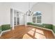 Bright living room features hardwood floors, large windows, a decorative chandelier, and wainscotting at 3035 Tavistock Dr, Durham, NC 27712