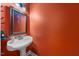 Stylish powder room features a pedestal sink, unique lighting and colorful accent wall at 3035 Tavistock Dr, Durham, NC 27712