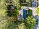 Aerial view of a property with a well-maintained yard, deck, and surrounded by mature trees at 3204 Terrel Mill Rd, Raleigh, NC 27616