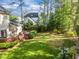 Spacious backyard featuring a well-maintained lawn, trees, and a wooden deck area for outdoor enjoyment at 3204 Terrel Mill Rd, Raleigh, NC 27616