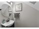 Bathroom featuring grey walls, a round mirror, towel rack, and a white sink at 3204 Terrel Mill Rd, Raleigh, NC 27616