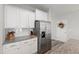 Modern kitchen featuring white cabinets, granite countertops, and stainless steel refrigerator at 321 Everly Mist Way, Wake Forest, NC 27587