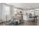 This open-concept kitchen and dining area features modern white cabinets, stainless steel appliances, and a stylish chandelier at 321 Everly Mist Way, Wake Forest, NC 27587