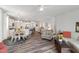 Open-concept living space featuring kitchen island, dining area, a cozy chair and sofa, all illuminated by natural light at 321 Everly Mist Way, Wake Forest, NC 27587