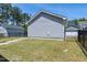 View of a backyard with green grass, a black fence, and a detached garage at 3224 Wishing Well Wynd, Apex, NC 27502