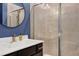Stylish bathroom featuring a glass-enclosed shower and modern vanity with a round mirror at 3224 Wishing Well Wynd, Apex, NC 27502