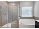 Bathroom featuring a glass shower, a soaking tub with a window, and a vanity at 3224 Wishing Well Wynd, Apex, NC 27502